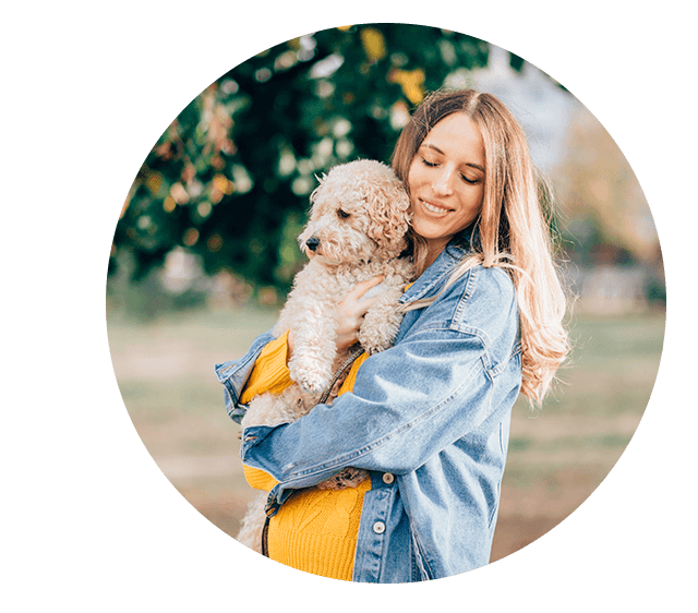 Frau mit ihrem für Allergiker geeigneten Hund auf dem Arm