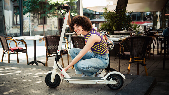 Junge Frau mit einem E-Scooter