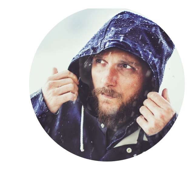 Mann bedeckt seinen Kopf bei Regen mit Kapuze als Symbolbild für Magazinartikel der VGH zum Thema Unwetterschutz