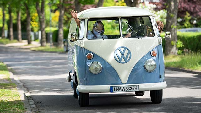 VW Bus blau weiß mit zwei jungen Frauen