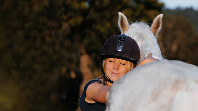 Tierhalterhaftpflicht für Pferde - Frau umarmt Pferd
