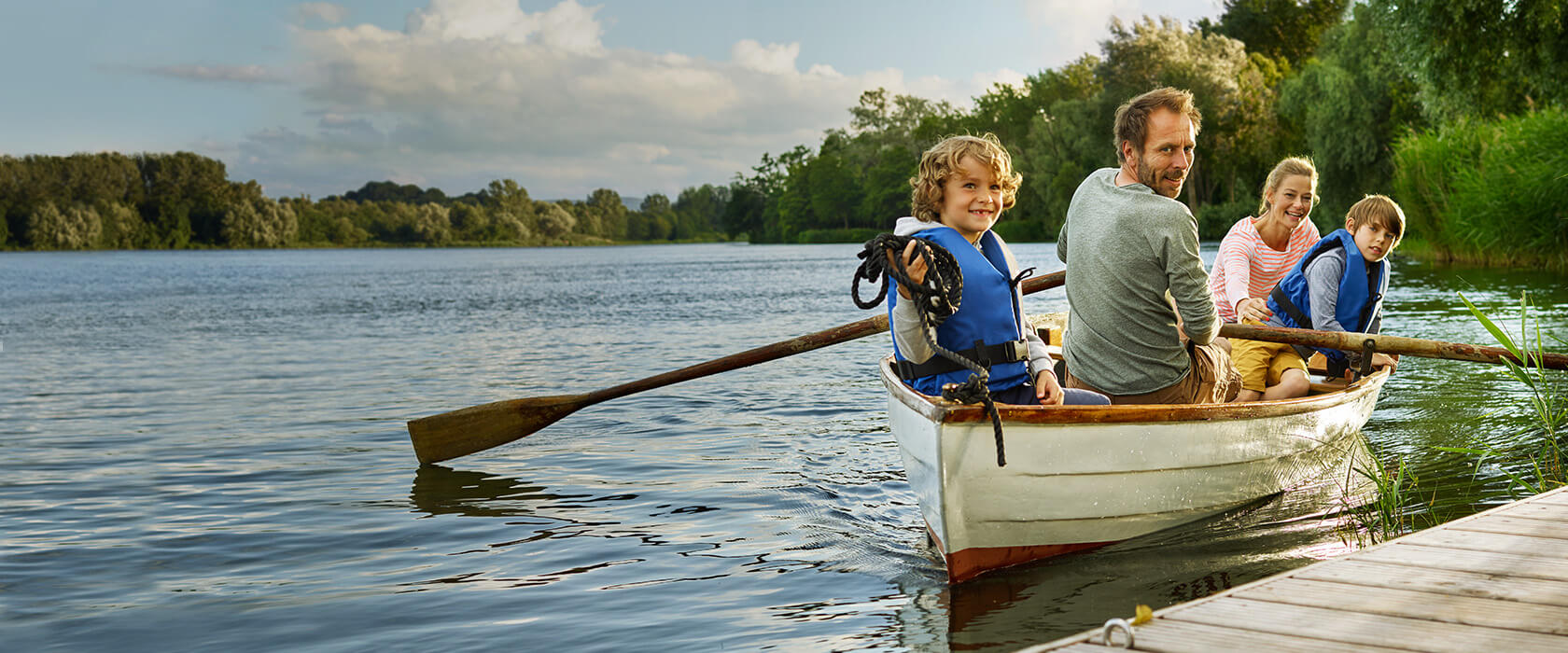 Vorsorge und Vermögen: eine bei der VGH versicherte Familie in einem  Boot auf einem See. 