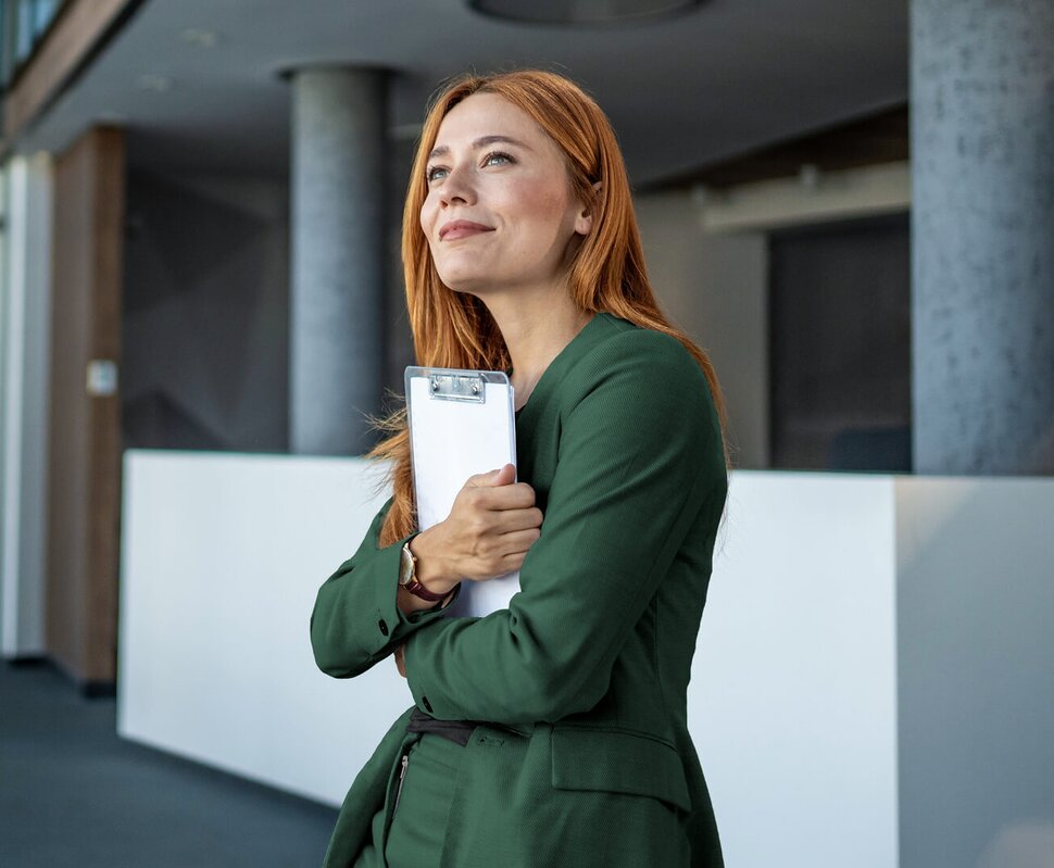 Zwei Männer im Geschäftsanzug sitzen in einem modern eingerichteten Büro und besprechen Dokumente. Sie lachen und sind freundlich.