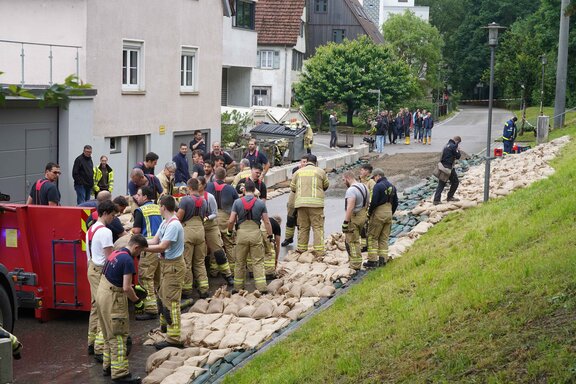 Remseck am Neckar bereitet sich im Juni 2024 auf einen Dammbruch in der Mühlstraße vor. Die Feuerwehr ist im Großeinsatz, befüllt Sandsäcke und organisiert weiteren mobilen Hochwasserschutz.